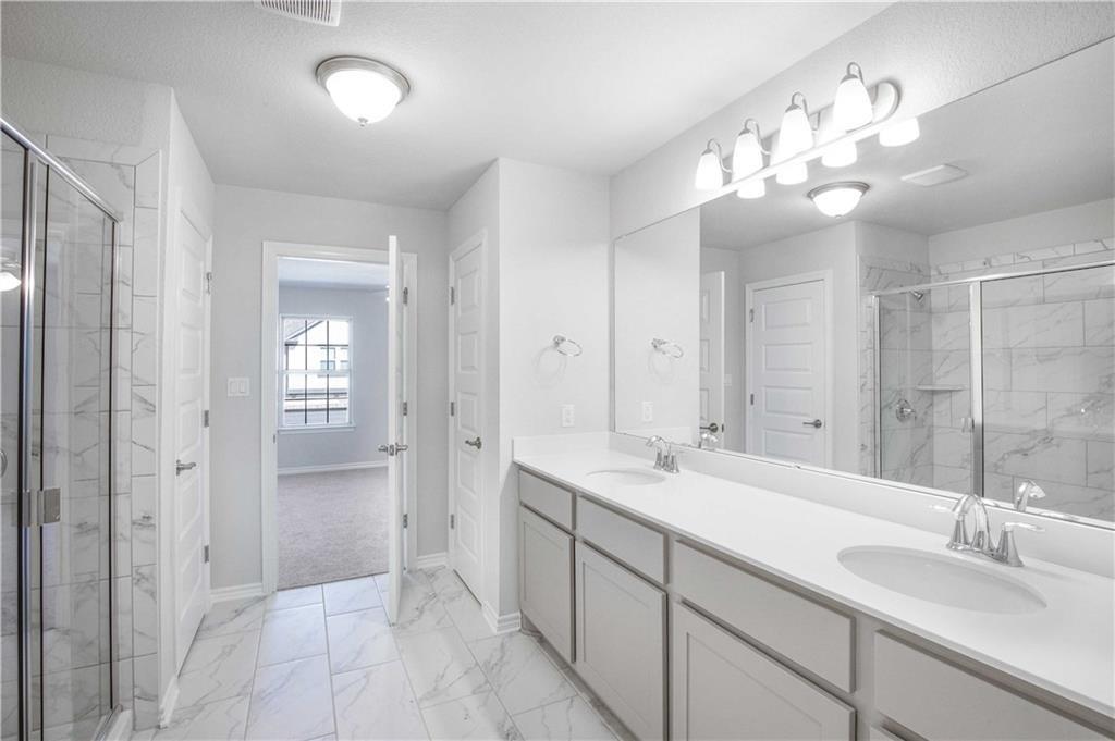 1616 Turtle Bay Loop Leander, TX 78641 - Photo 27 of 33 a spacious bathroom with a granite countertop sink a mirror and a shower