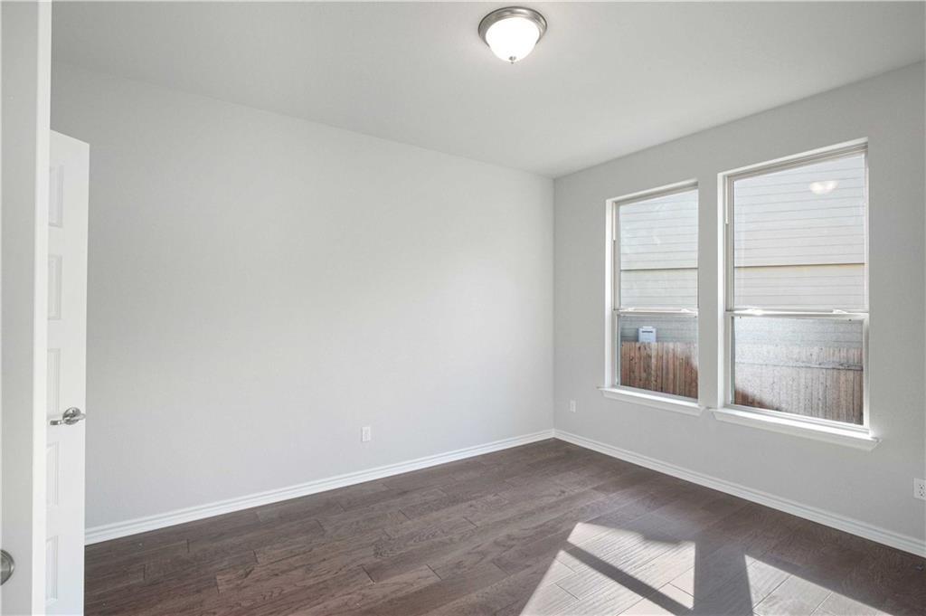 1616 Turtle Bay Loop Leander, TX 78641 - Photo 32 of 33 an empty room with wooden floor and windows