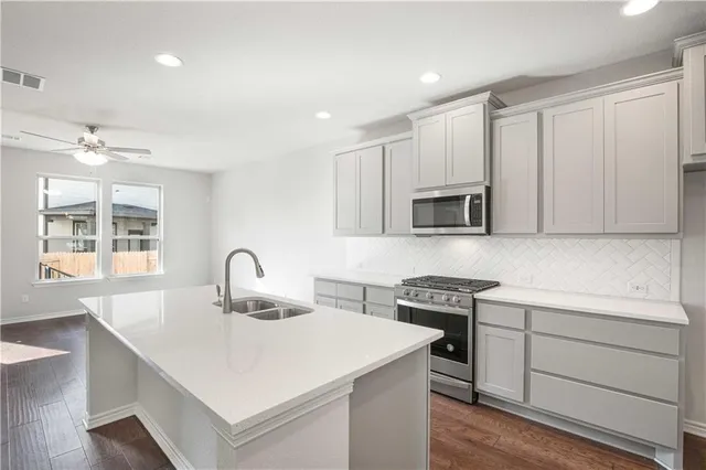 a kitchen with a sink a stove and cabinets