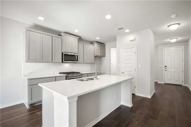 a kitchen with a sink a stove a refrigerator a center island and a window