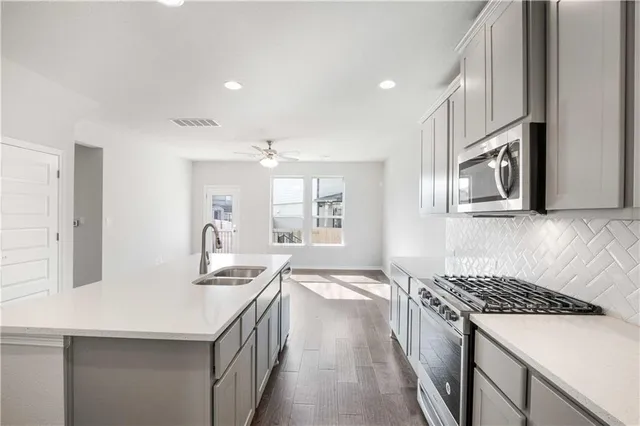 a kitchen with granite countertop a sink stove and cabinets