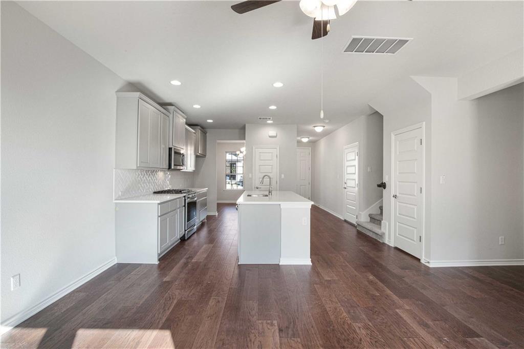 1616 Turtle Bay Loop Leander, TX 78641 - Photo 9 of 33 a living room with stainless steel appliances kitchen island hardwood floor and a sink
