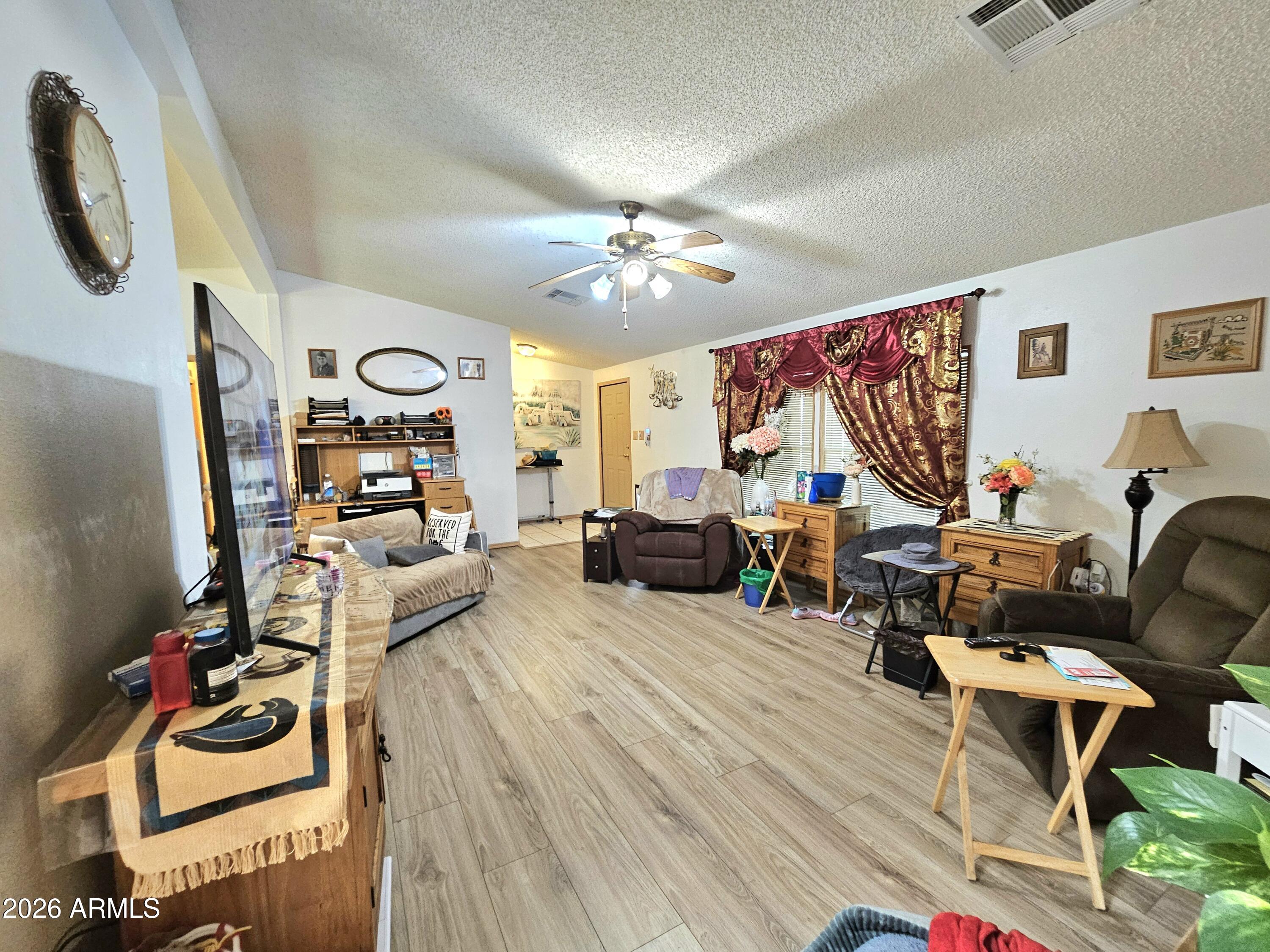 3145 West Citrus Road Benson, AZ 85602 - Photo 20 of 36 a living room with furniture a flat screen tv and gym equipment