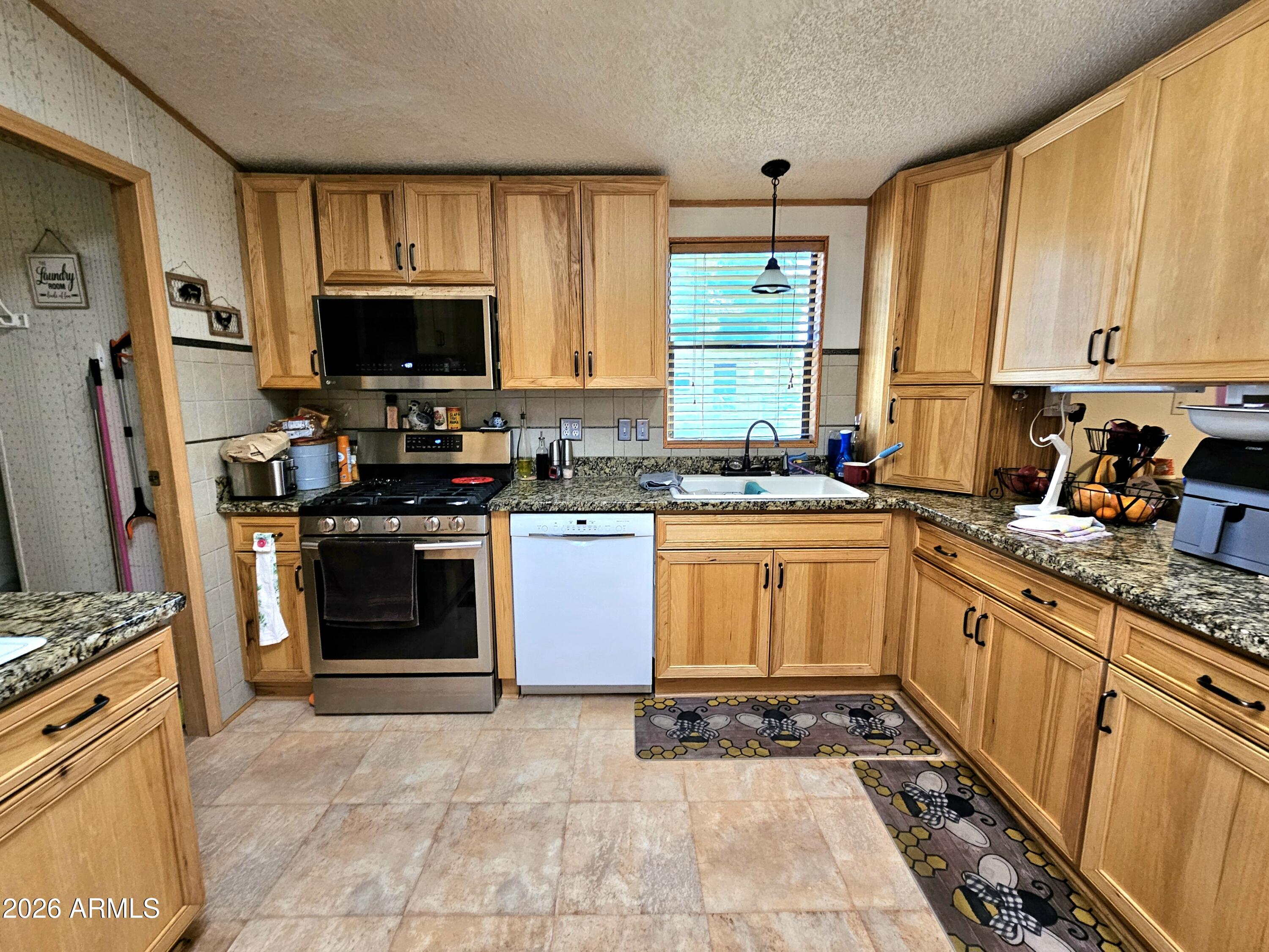3145 West Citrus Road Benson, AZ 85602 - Photo 24 of 36 a kitchen with stainless steel appliances granite countertop a stove sink and microwave