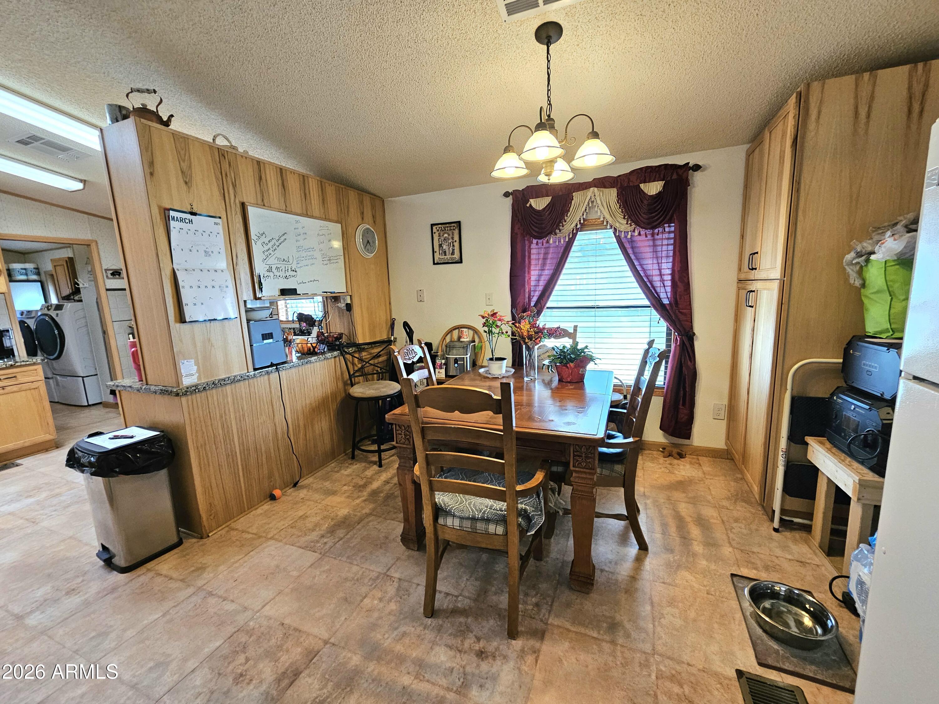 3145 West Citrus Road Benson, AZ 85602 - Photo 25 of 36 a dining room with furniture a chandelier and window