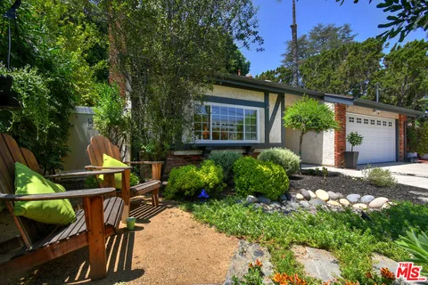 a front view of a house with a garden