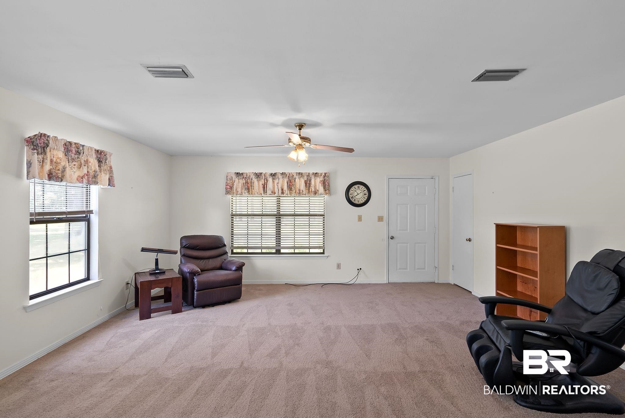 20540 Lacey Road Silverhill, AL 36576 - Photo 6 of 40 Spacious room with plush carpet flooring, two windows with blinds, a ceiling fan with integrated lighting, and a paneled door