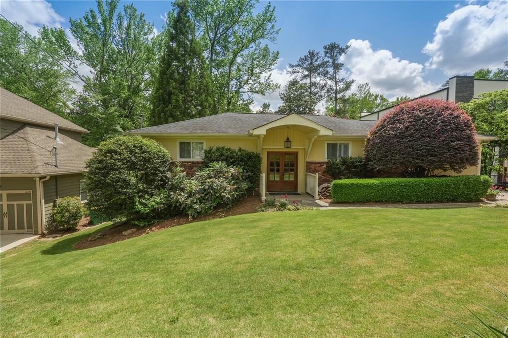 a view of a house with a yard and sitting area
