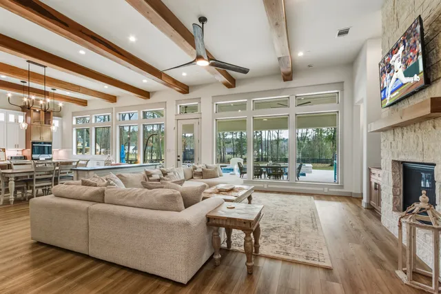 a kitchen with stainless steel appliances granite countertop a refrigerator a sink dishwasher a stove and white countertops with wooden floor