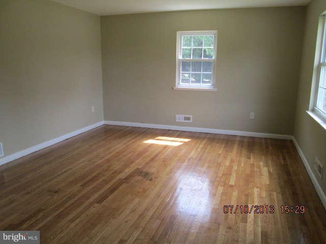 601 Crosby Road Baltimore, MD 21228 - Photo 9 of 16 an empty room with wooden floor and windows