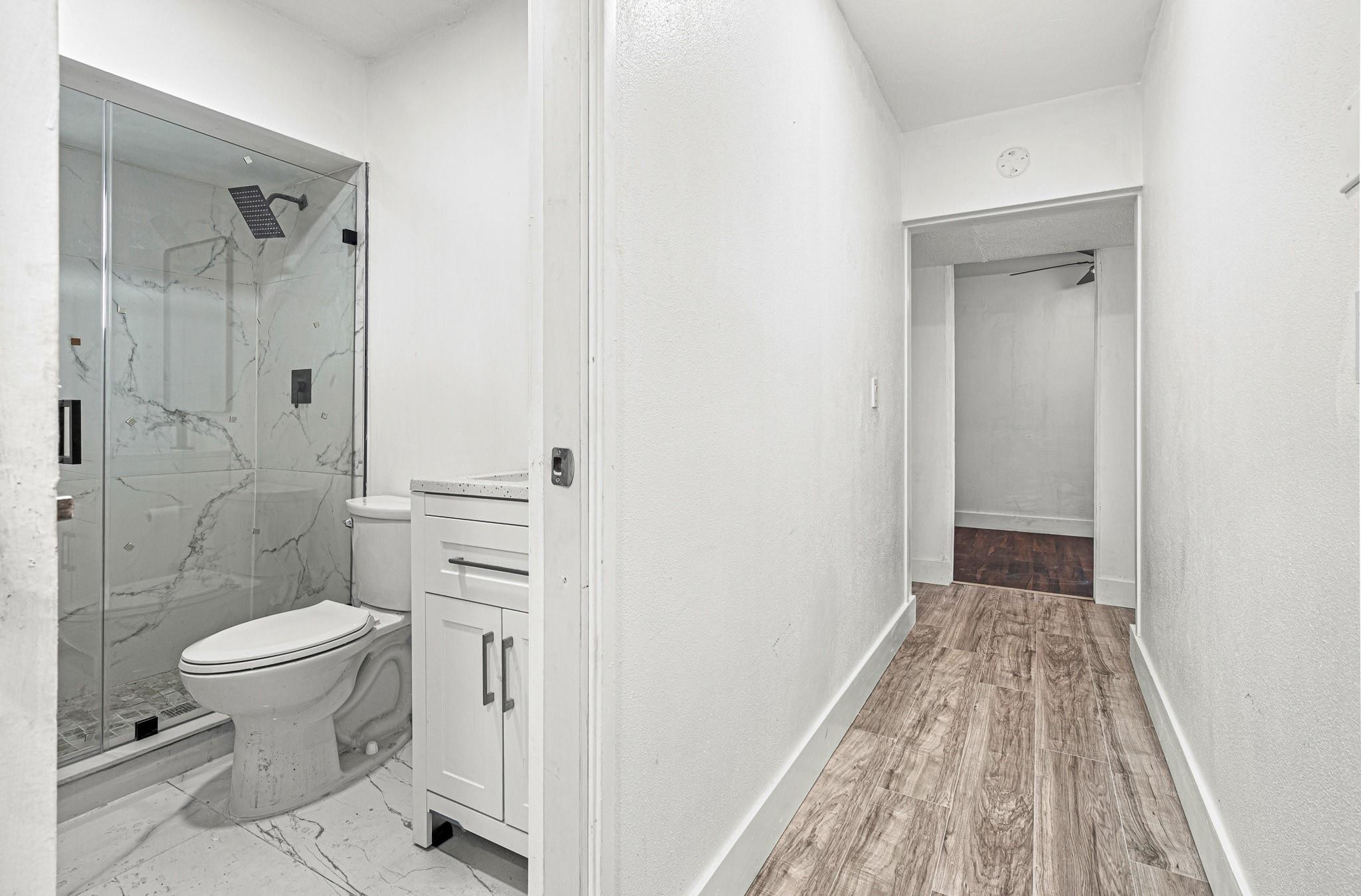 7007 Northwest 64th Street Tamarac, FL 33321 - Photo 11 of 46 a bathroom with a granite countertop toilet a sink and shower