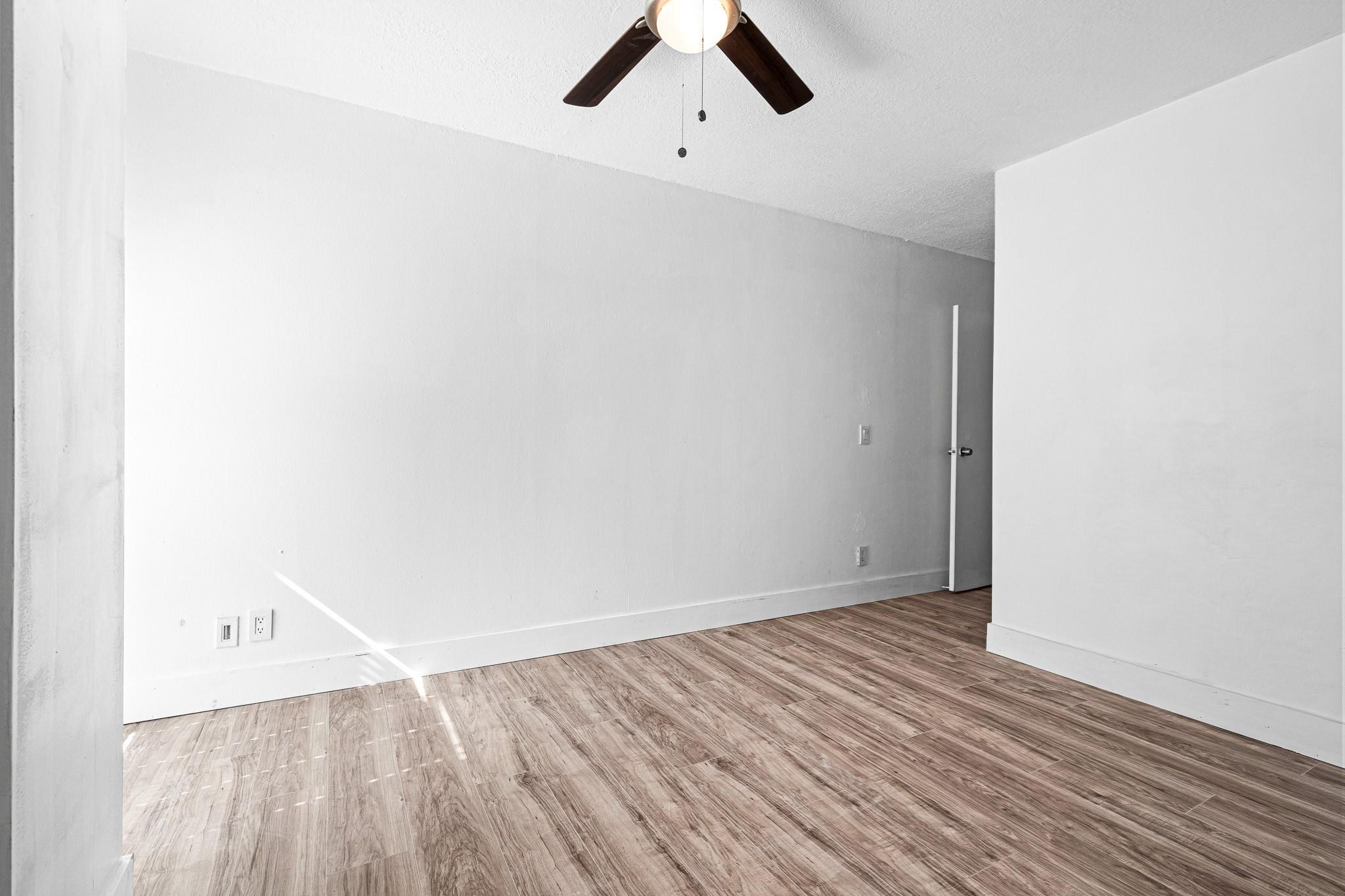 7007 Northwest 64th Street Tamarac, FL 33321 - Photo 18 of 46 a view of an empty room with wooden floor