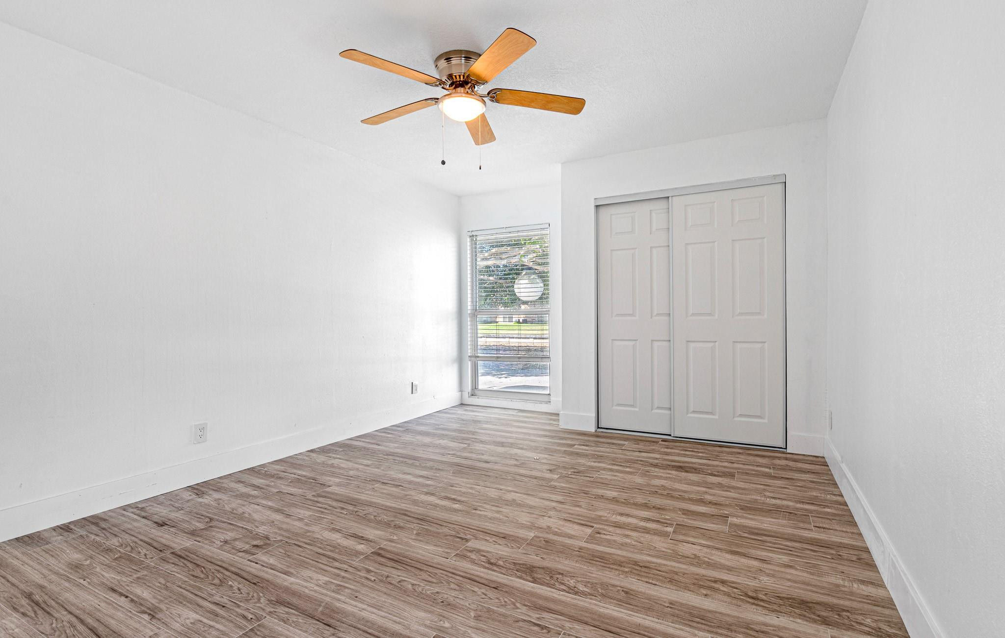 7007 Northwest 64th Street Tamarac, FL 33321 - Photo 20 of 46 a view of a room with wooden floor and a ceiling fan