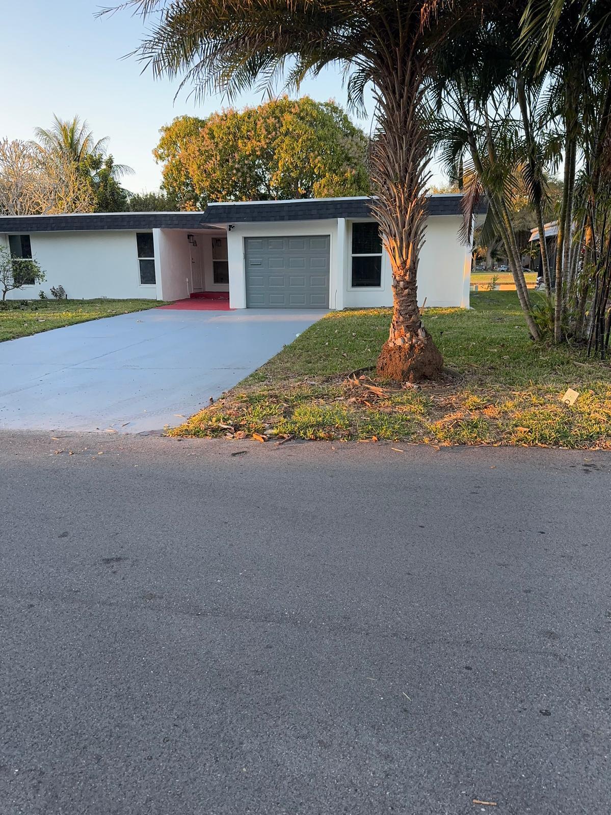 7007 Northwest 64th Street Tamarac, FL 33321 - Photo 2 of 46 a front view of house with yard and trees