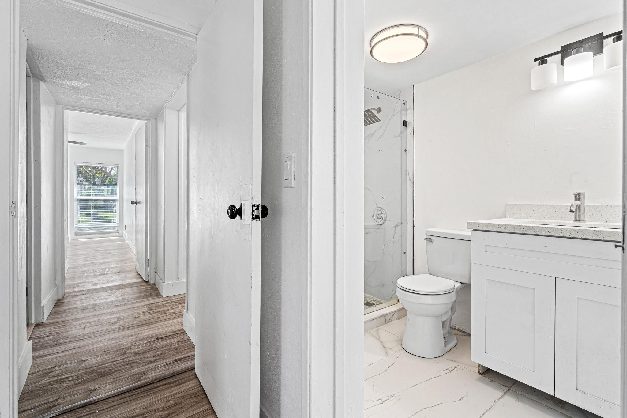 7007 Northwest 64th Street Tamarac, FL 33321 - Photo 22 of 46 a bathroom with a toilet a sink a mirror and vanity