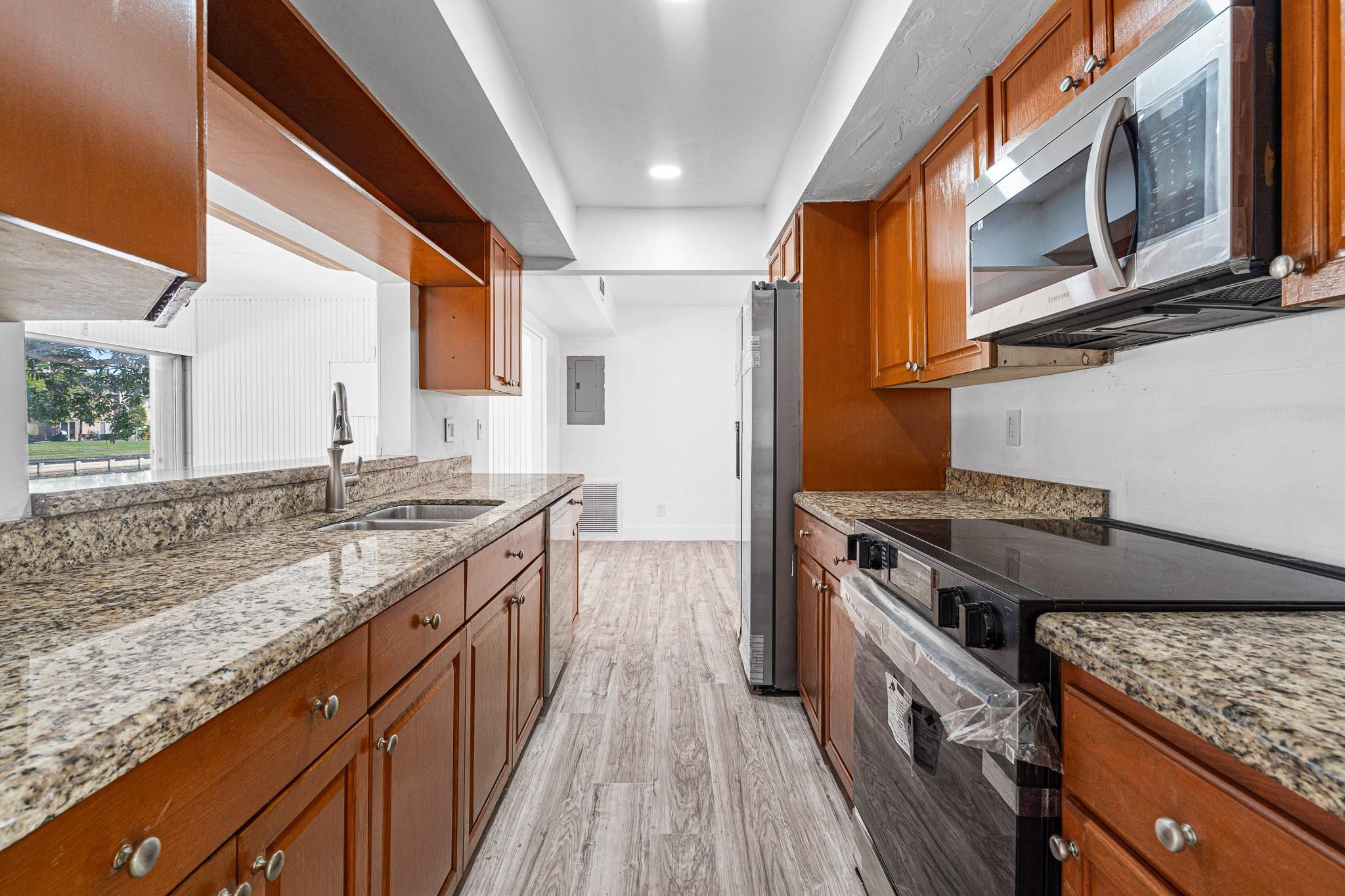 7007 Northwest 64th Street Tamarac, FL 33321 - Photo 23 of 46 a kitchen with stainless steel appliances granite countertop a stove and a sink