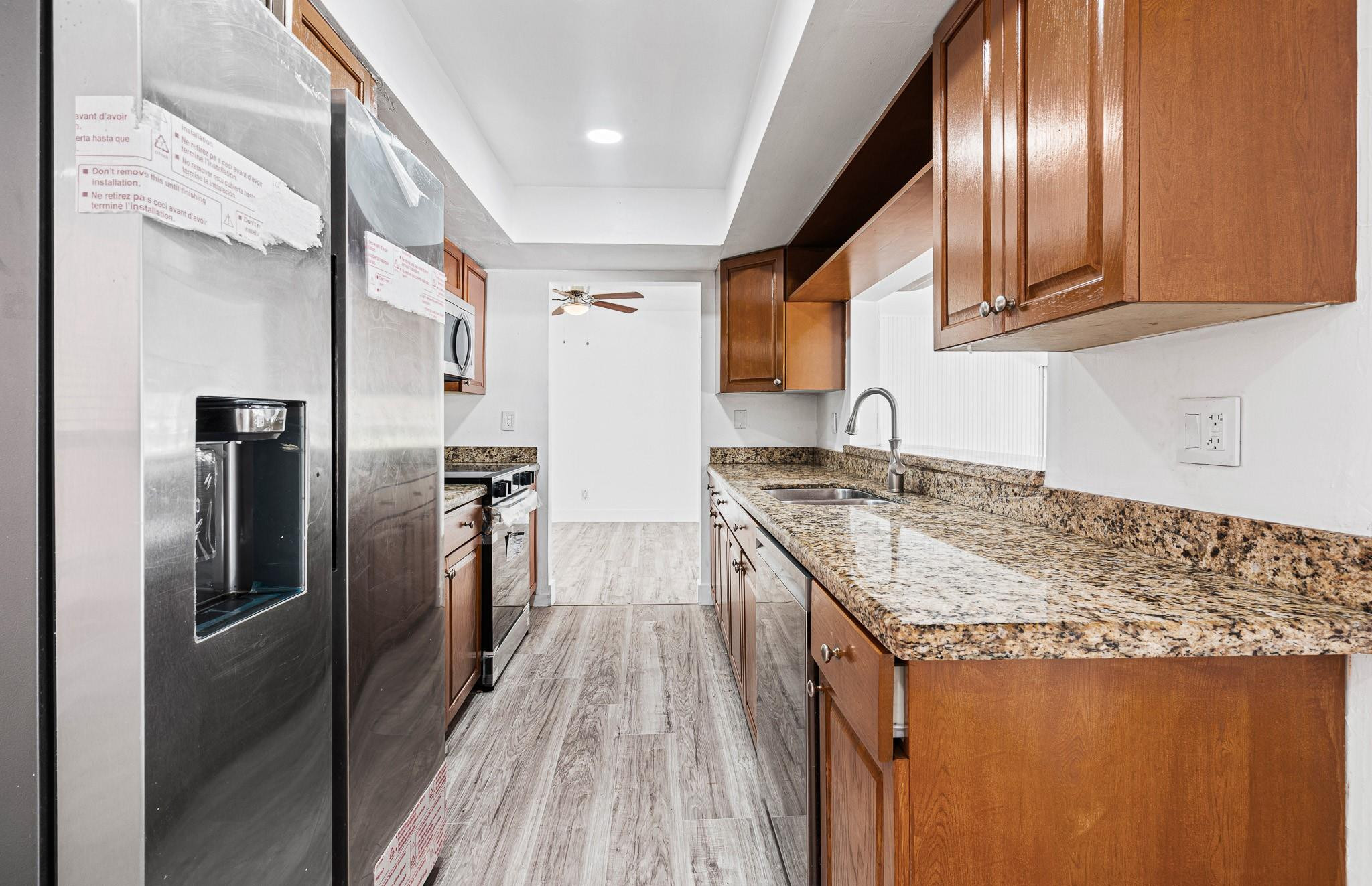 7007 Northwest 64th Street Tamarac, FL 33321 - Photo 24 of 46 a kitchen with granite countertop stainless steel appliances a sink stove and refrigerator