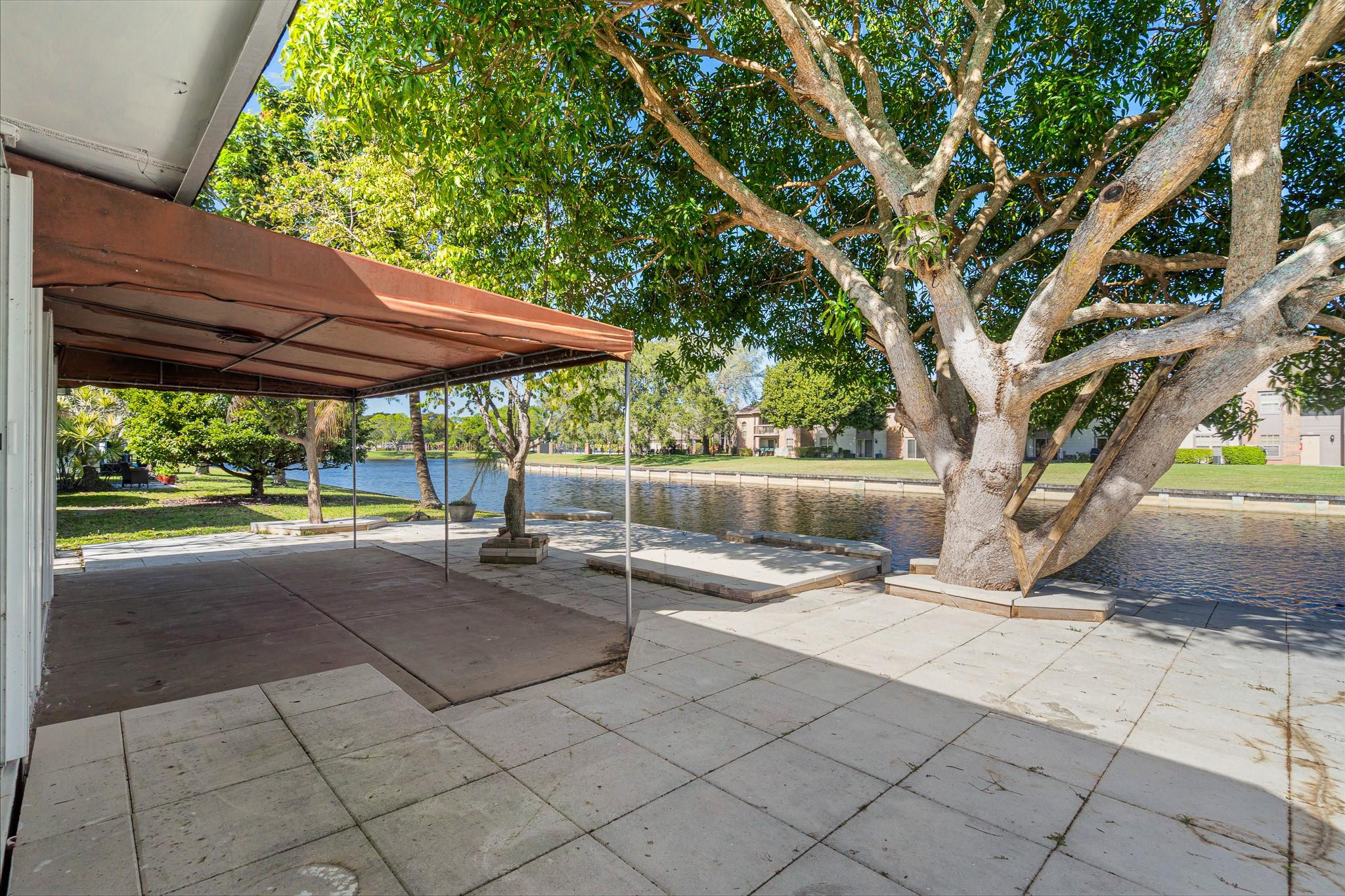7007 Northwest 64th Street Tamarac, FL 33321 - Photo 30 of 46 a view of backyard with a table and chairs under an umbrella