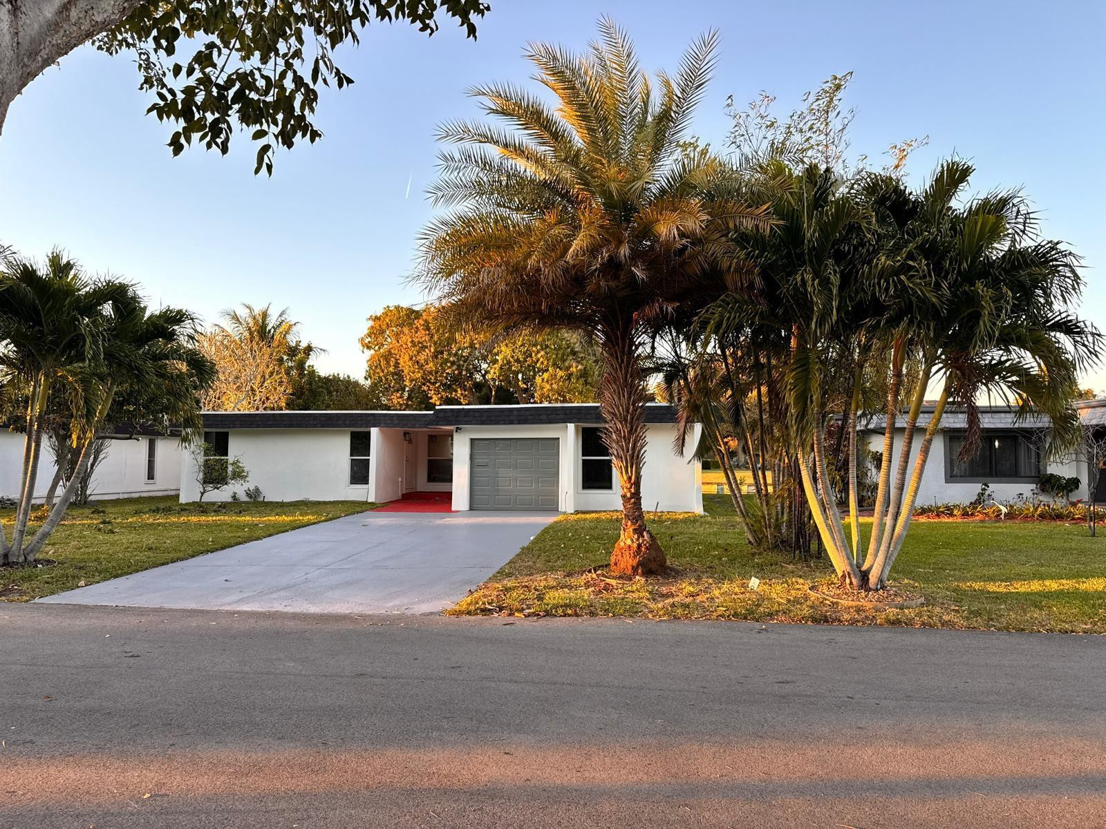 7007 Northwest 64th Street Tamarac, FL 33321 - Photo 3 of 46 a view of a house with a yard and palm trees