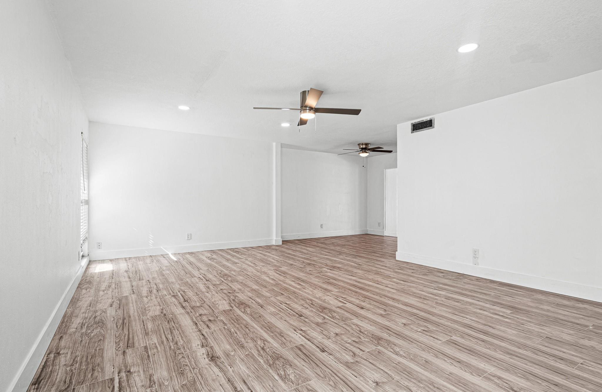 7007 Northwest 64th Street Tamarac, FL 33321 - Photo 5 of 46 a view of a room with wooden floor and a ceiling fan