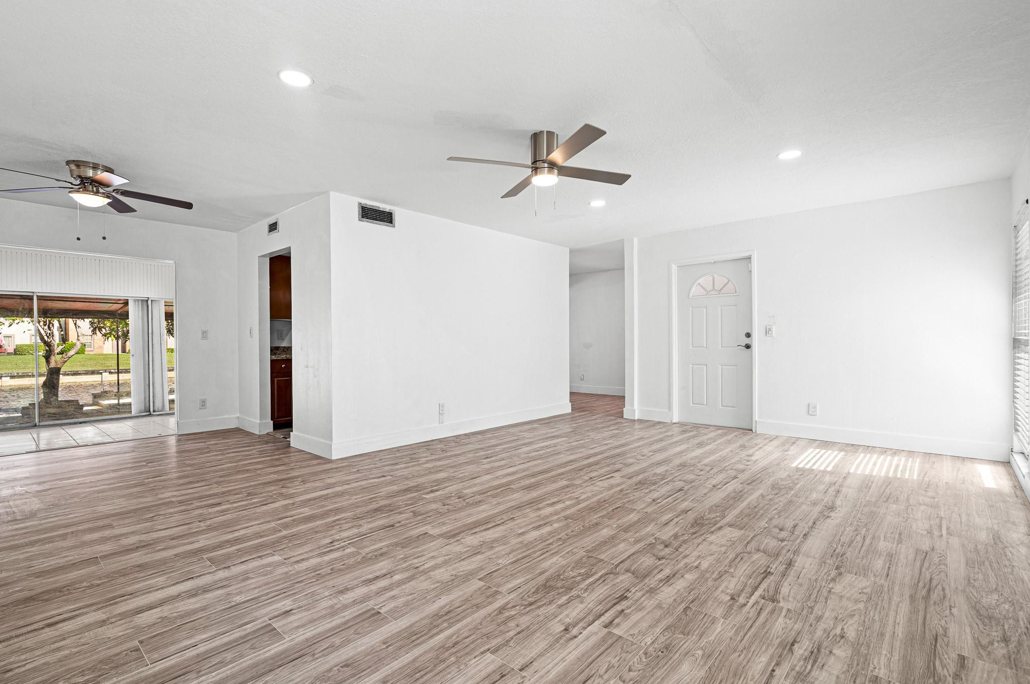 7007 Northwest 64th Street Tamarac, FL 33321 - Photo 6 of 46 a view of empty room with wooden floor and fan
