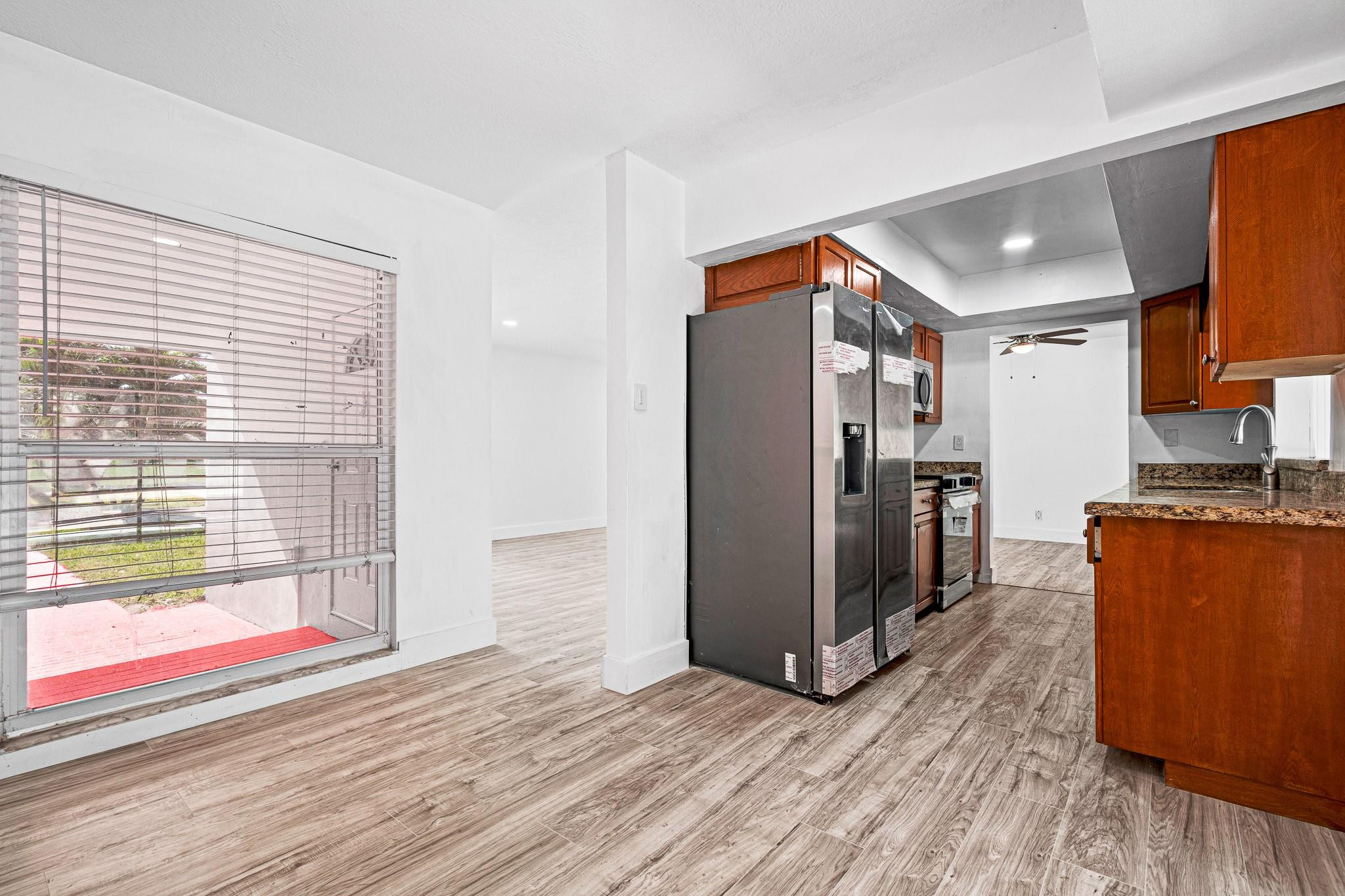 7007 Northwest 64th Street Tamarac, FL 33321 - Photo 10 of 46 a view of a kitchen with wooden floor and a refrigerator