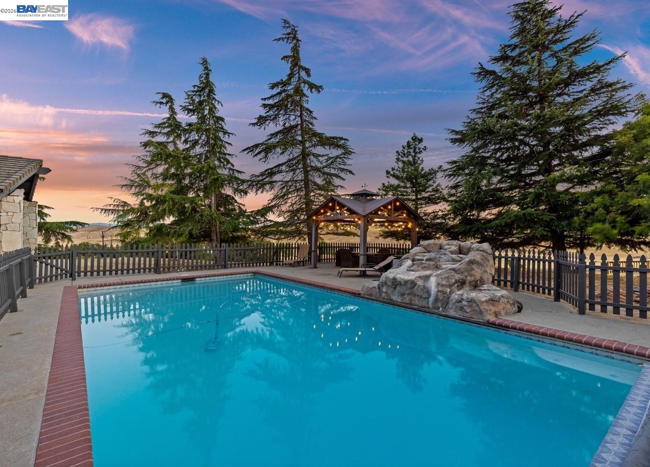 8191 Highland Road Livermore, CA 94551 - Photo 34 of 59 a view of a swimming pool with a bench and trees around