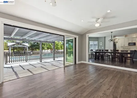 a view of a dining room and livingroom with furniture wooden floor a chandelier