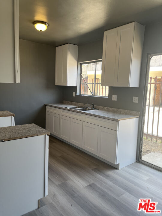 602 North Sloan Avenue, Unit A Compton, CA 90221 - Photo 8 of 9 a kitchen with granite countertop a sink a stove and cabinets