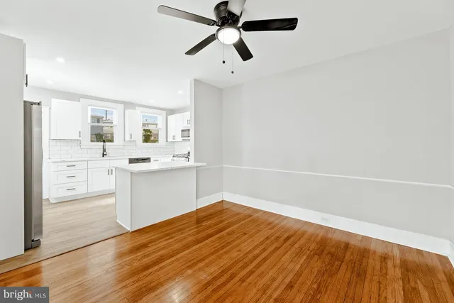 a view of a kitchen with a sink and dishwasher with white cabinets
