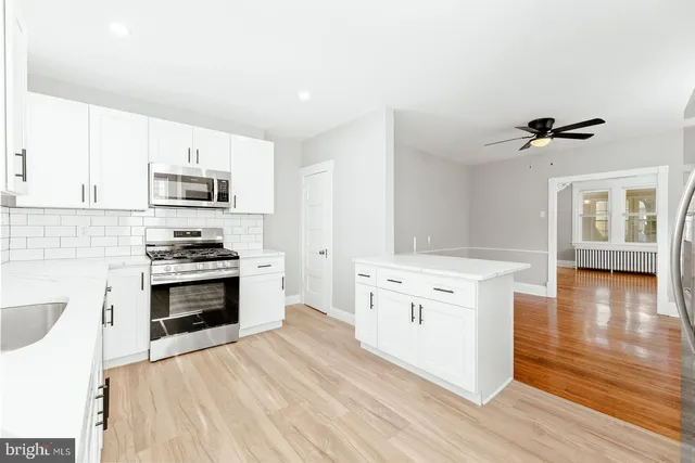 a kitchen with granite countertop a stove top oven a sink dishwasher and a refrigerator with wooden floor