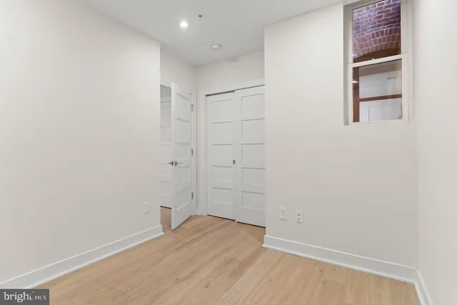 a view of empty room with wooden floor