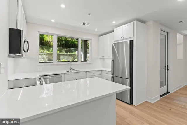a kitchen with a refrigerator a sink and a cabinets