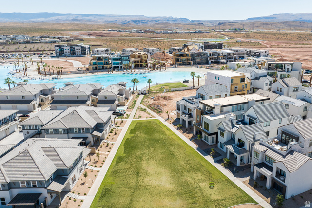 Aerial depiction of a planned community featuring a large water amenity, multiple residential structures, and landscaped green spaces