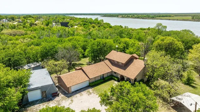 an aerial view of a house with garden space and lake view