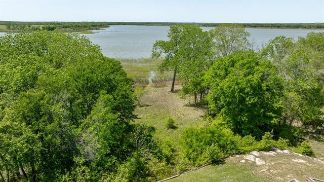 a view of a lake with a yard and mountain in the back
