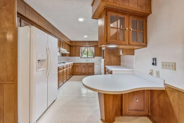 a kitchen with stainless steel appliances granite countertop a sink and refrigerator