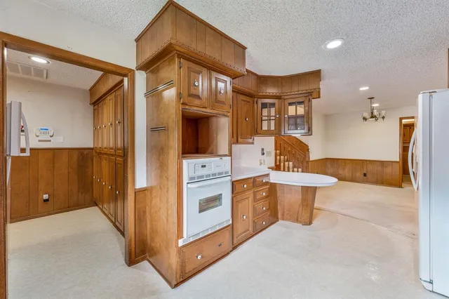 a view of a kitchen with stainless steel appliances wooden floor and windows