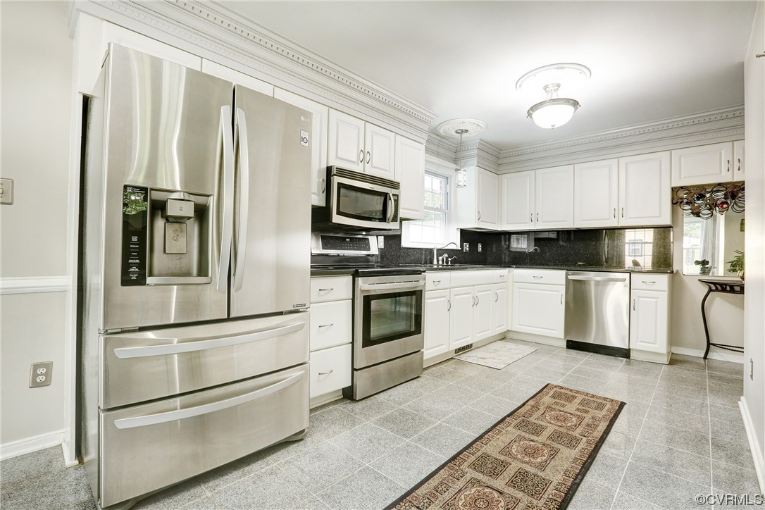 6723 Cherry Road Quinton, VA 23141 - Photo 5 of 44 a kitchen with white cabinets and stainless steel appliances