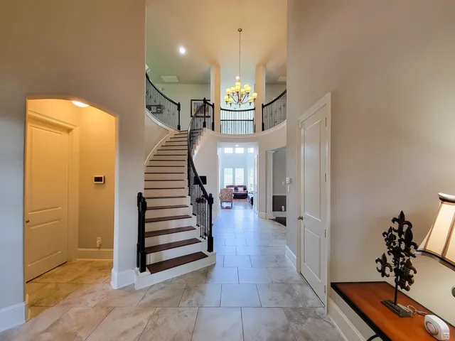 a view of a hallway with entryway and stairs