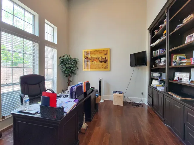 a living room with furniture a bookshelf and a wooden floor