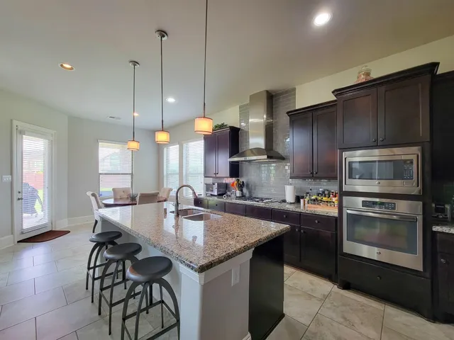 a kitchen with granite countertop a sink stainless steel appliances and cabinets