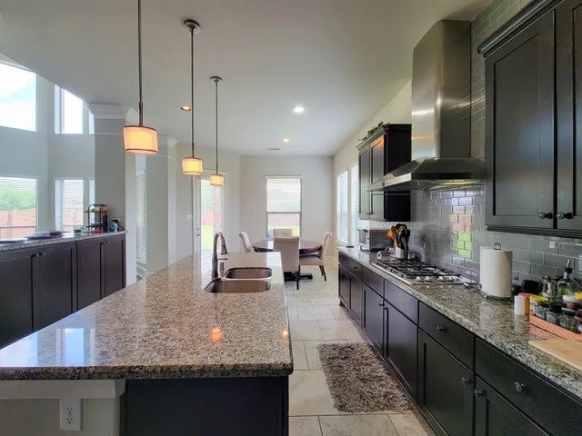 a kitchen with stainless steel appliances granite countertop a sink stove and refrigerator