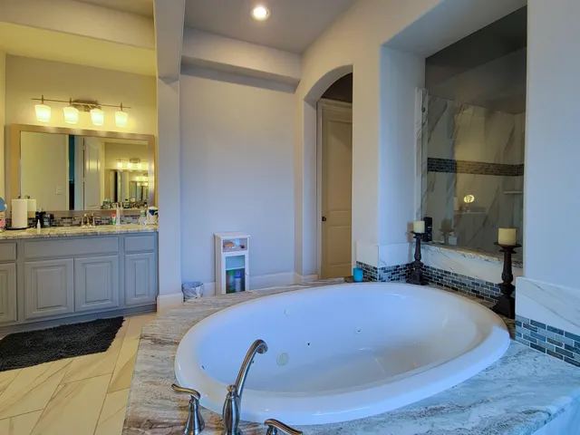 a bathroom with a tub and mirror