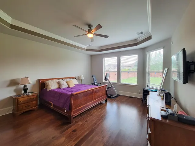a living room with a bed furniture flat screen tv and a large window
