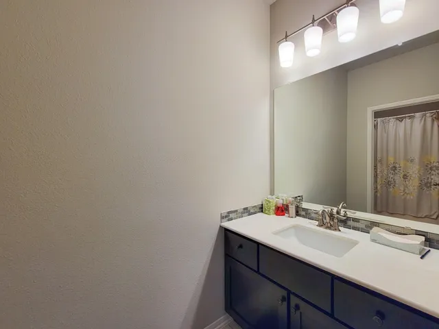a bathroom with a sink vanity and a mirror