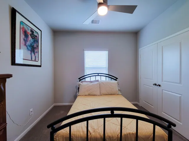 a bedroom with a bed and a painting on the wall