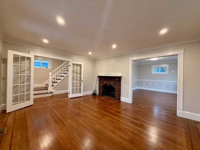 an empty room with wooden floor and fireplace