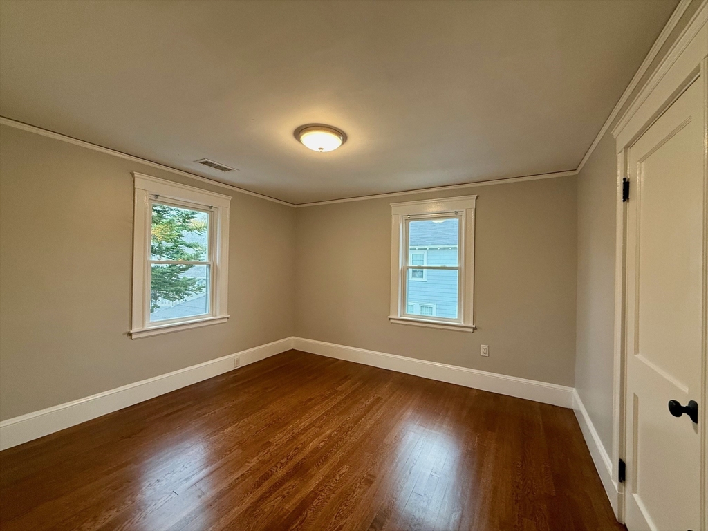 224 Faneuil Street, Unit 1 Boston, MA 02135 - Photo 11 of 19 a view of an empty room with wooden floor and a window