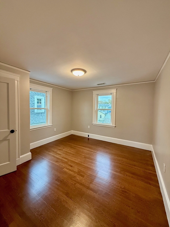 224 Faneuil Street, Unit 1 Boston, MA 02135 - Photo 13 of 19 an empty room with wooden floor and windows
